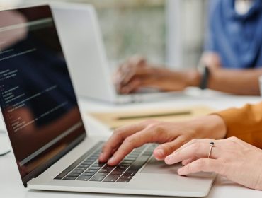 Female programmer typing codes on laptop